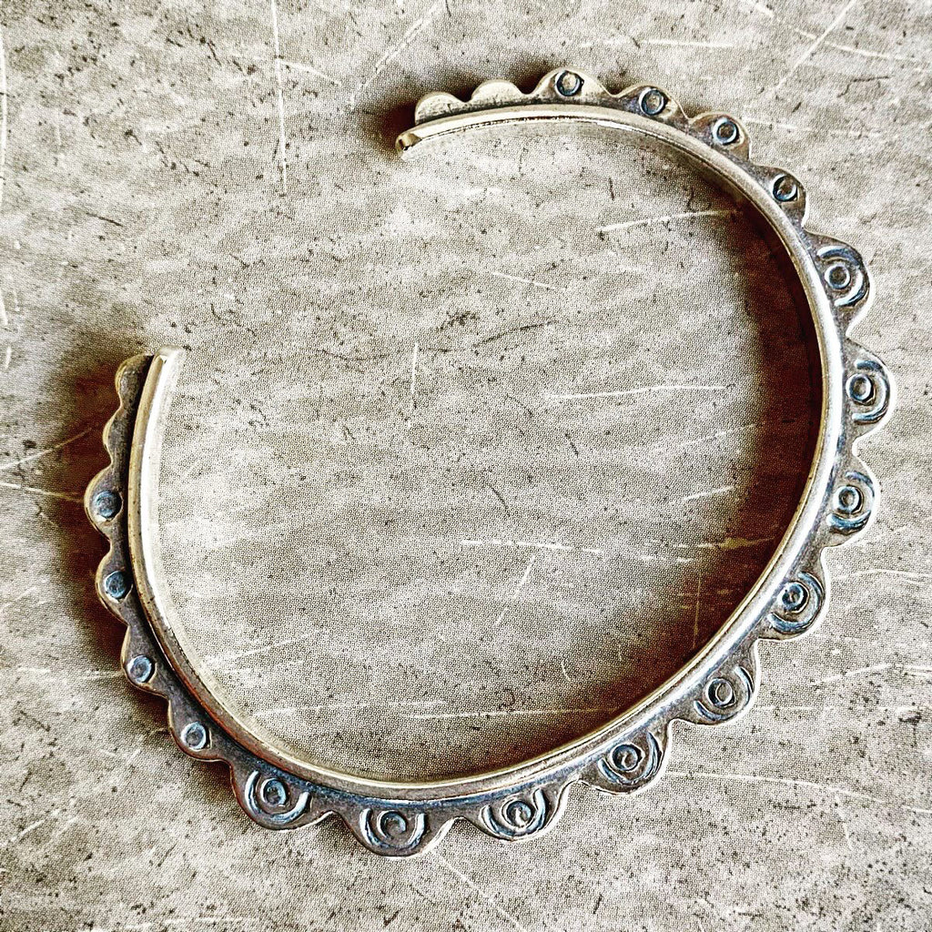 Silver hoop earring on a textured beige surface