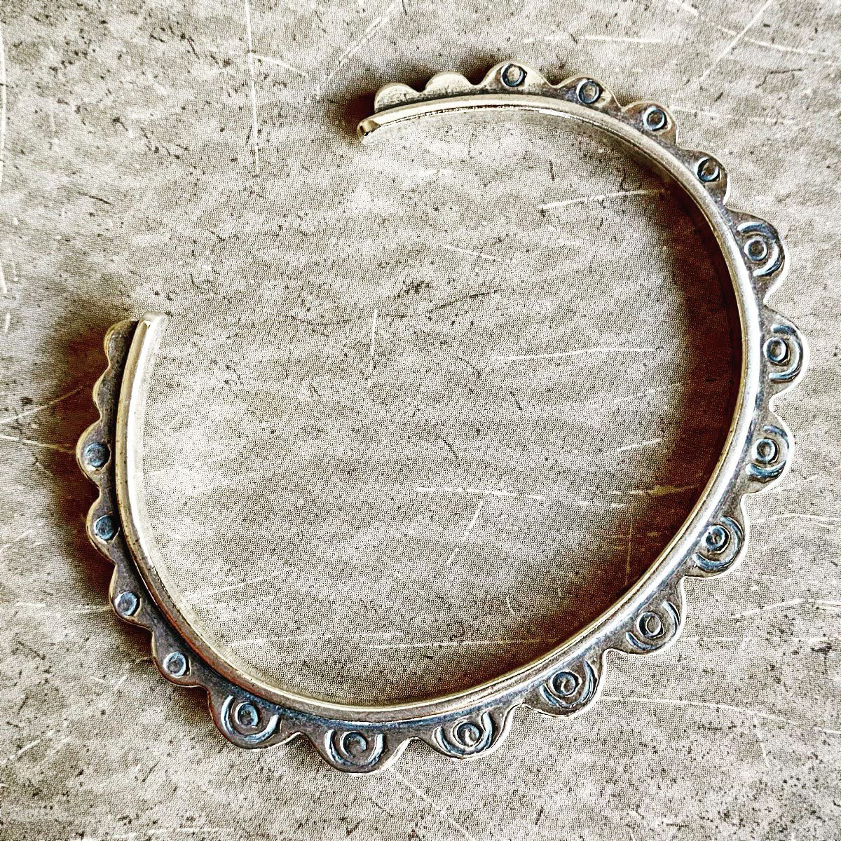 Silver hoop earring on a textured beige surface