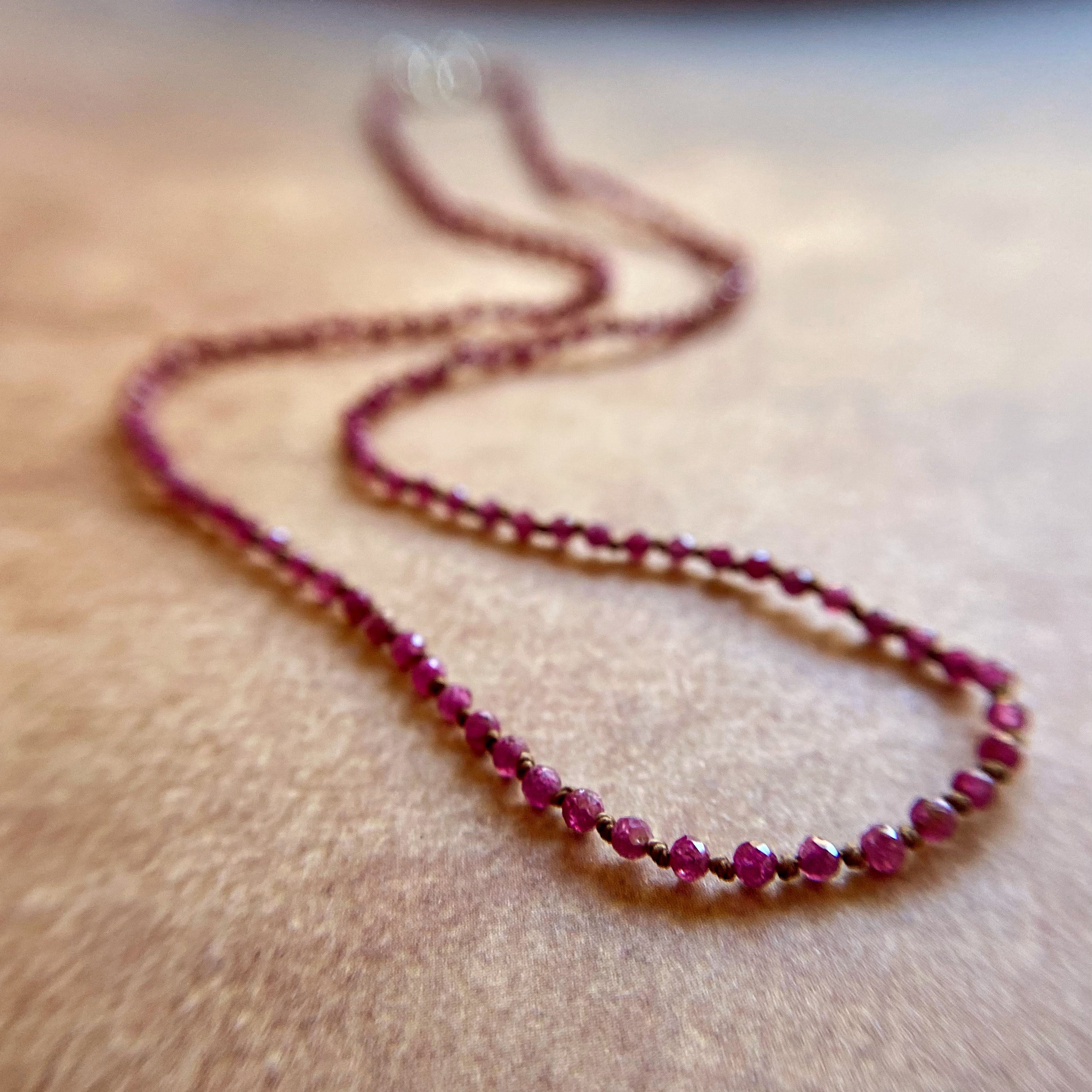 Necklace with red beads on a wooden surface