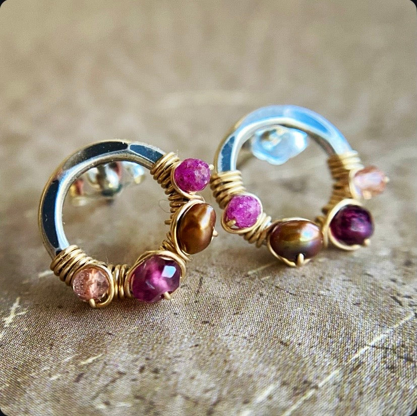 Pair of hoop earrings with gemstones on a textured surface