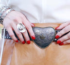Close-up of a person wearing a decorative belt with intricate designs and a ten gallon cowboy hat ring.